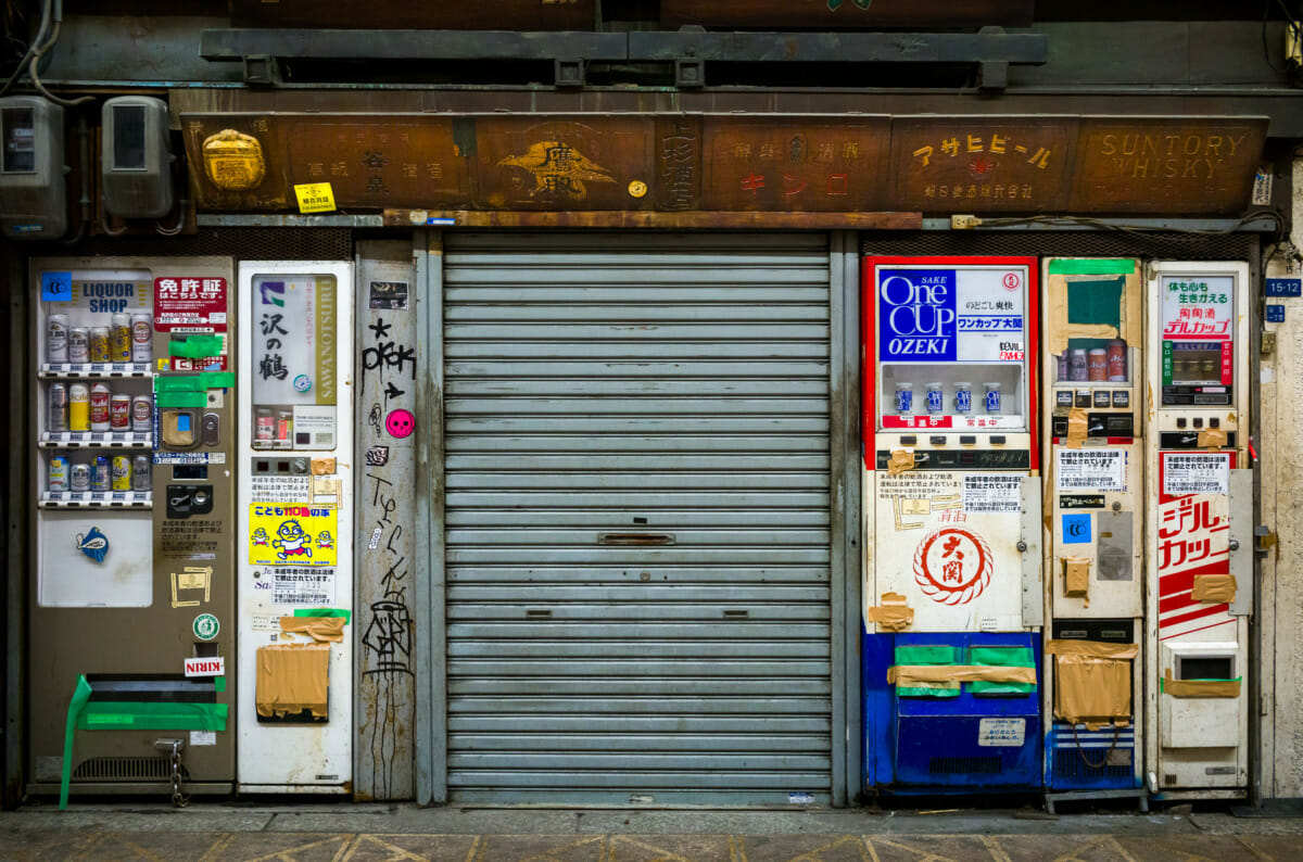 broken and taped up Japanese booze vending machines