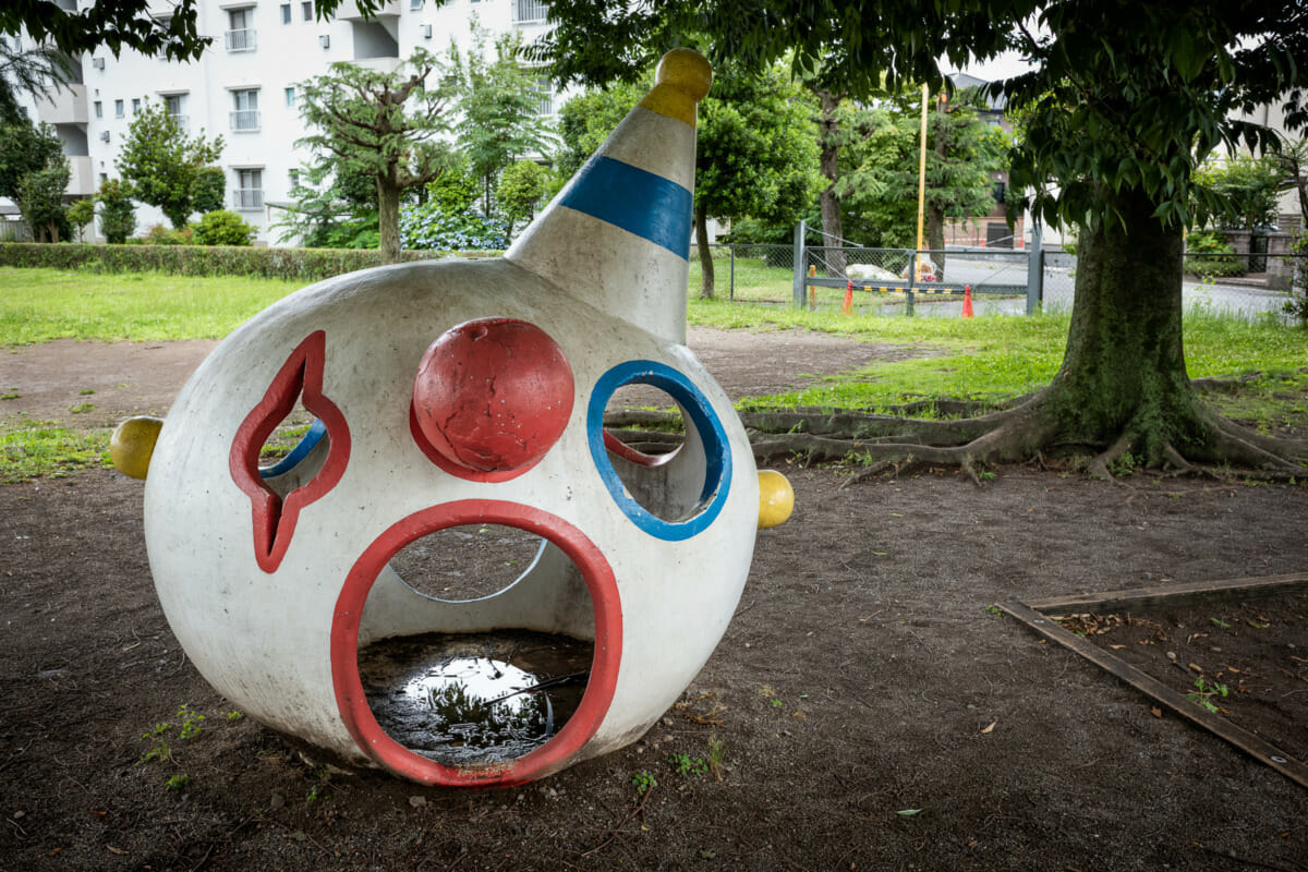 a disturbing concrete clown head in a Japanese playground