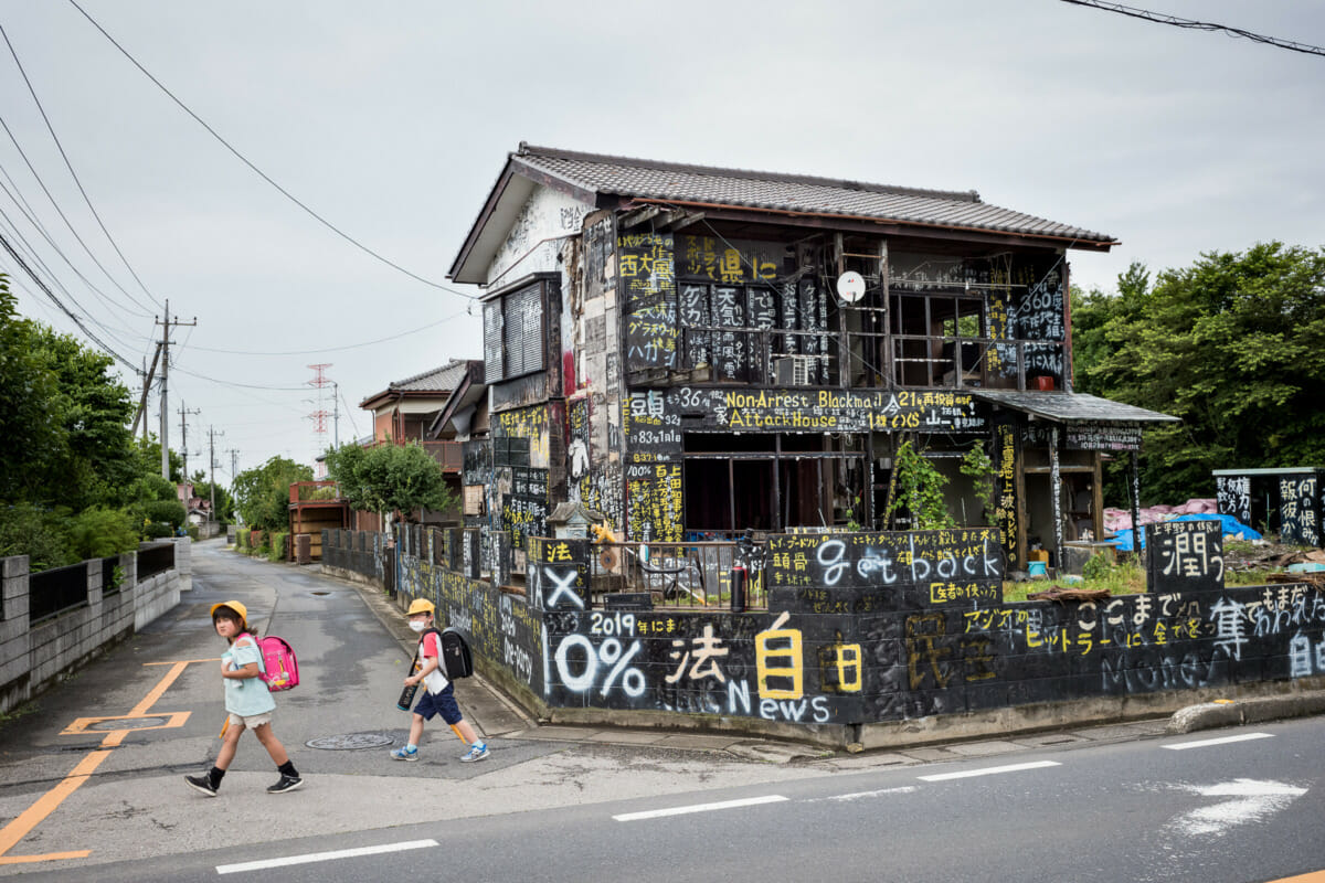 a dilapidated and kanji daubed Japanese house