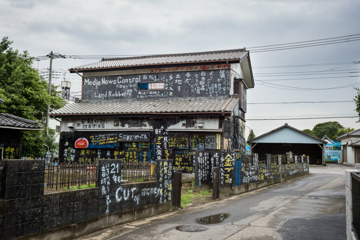 a dilapidated and kanji daubed Japanese house