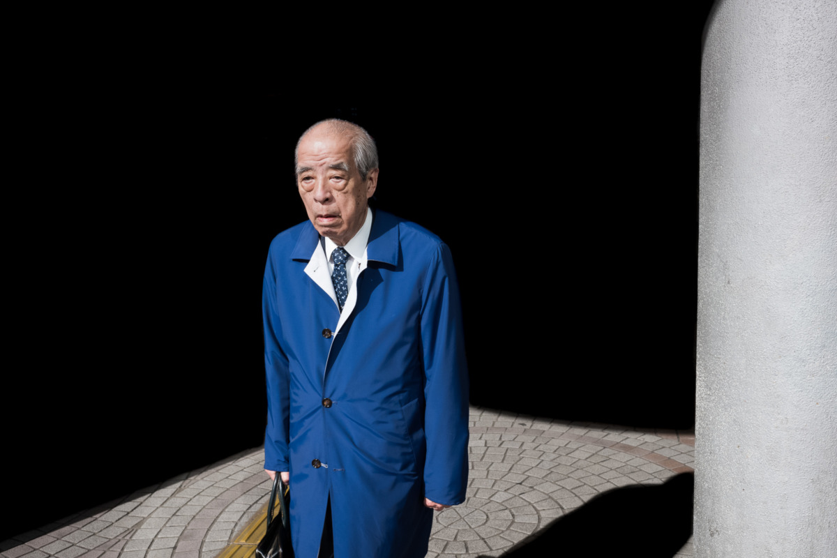 an old Tokyo salaryman dressed in blue