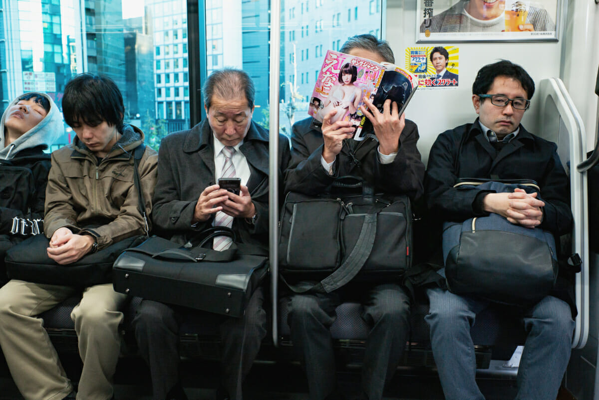 A Japanese salaryman reading adult manga on the morning commute