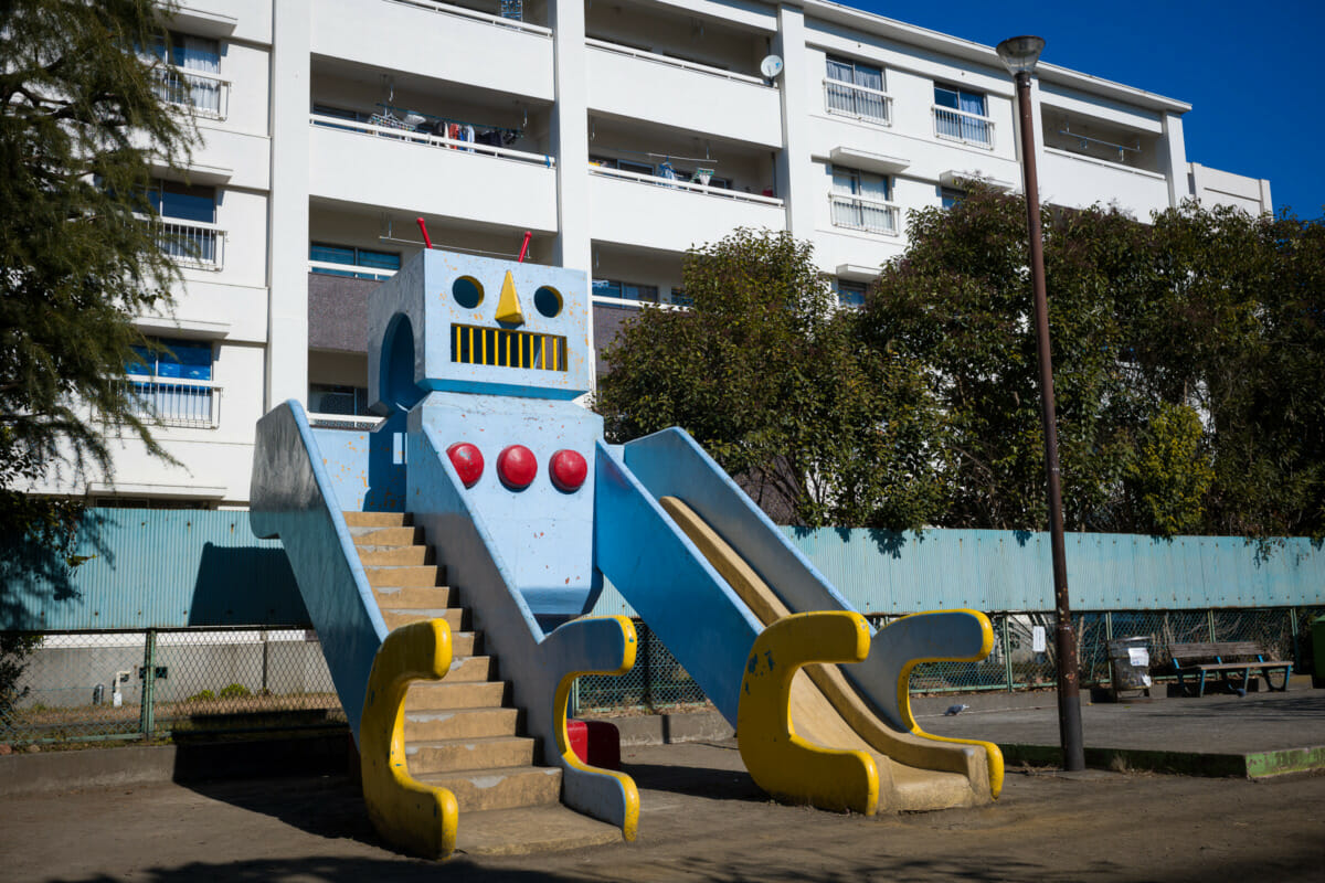 A large and retro concrete robot in an urban Tokyo park