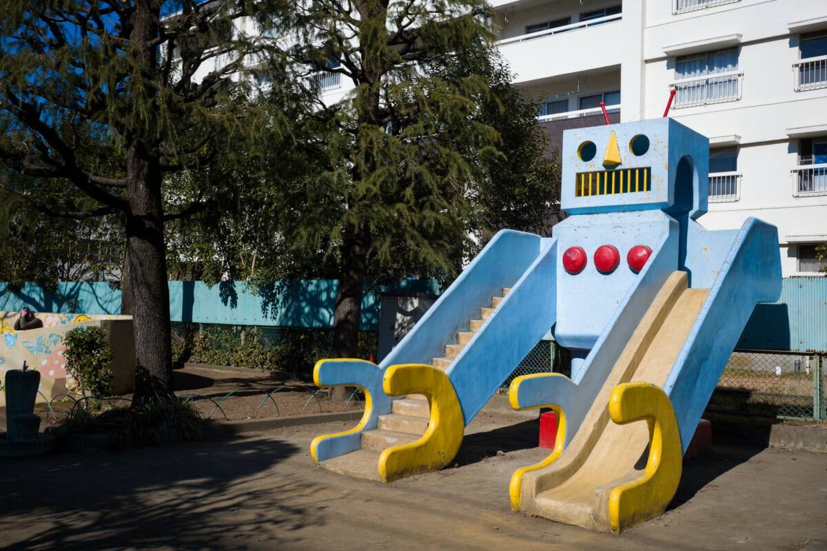 A large and retro concrete robot in an urban Tokyo park